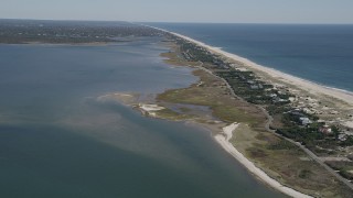 AX91_231 - 4K aerial stock footage of flying away from beach and coastal homes by Shinnecock Bay, Southampton, New York