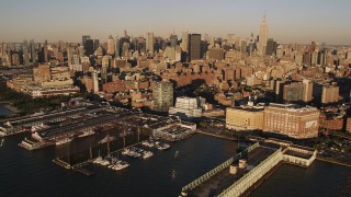 AX93_005 - 4K aerial stock footage of Midtown Manhattan, from Chelsea Piers, New York, New York, sunset