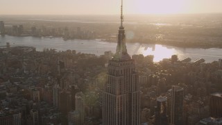 AX93_034 - 4K aerial stock footage Flying by the Empire State Building, Midtown Manhattan, New York, sunset