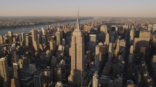 AX93_041 - 4K aerial stock footage Flying by the Empire State Building, Midtown Manhattan, New York, sunset