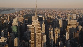 AX93_042 - 4K stock footage aerial video Flying by the Empire State Building, Midtown Manhattan, New York, sunset