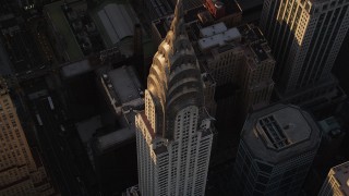 AX93_050 - 4K aerial stock footage Flying away from Chrysler Building, tilting up, Midtown Manhattan, New York, sunset