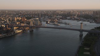 AX93_058 - 4K aerial stock footage Approaching the Williamsburg Bridge, East River, New York, New York, sunset