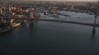 AX93_059 - 4K aerial stock footage Approaching Williamsburg Bridge, East River, New York, New York, sunset