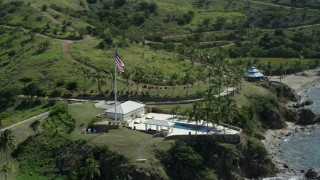 AX96_163 - 5k stock footage aerial stock footage orbiting flag and pool and fly away on Little St James Island, St Thomas, Virgin Islands