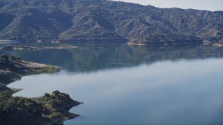 AXSF01_017 - 5K aerial stock footage Flying low over grassy hill, revealing Lake Casitas, Ventura, California