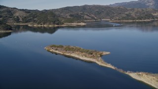 AXSF01_021 - 5K aerial stock footage of following an aqueduct uphill, revealing Casitas Dam, Lake Casitas, California