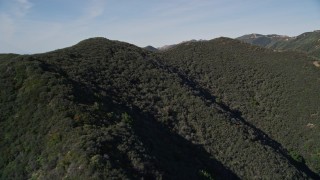 AXSF01_026 - 5K aerial stock footage of approaching the tree covered mountains, Santa Ynez Mountains, California