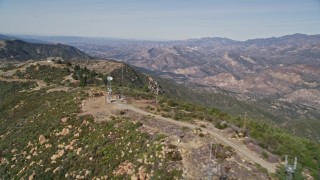 AXSF01_035 - 5K aerial stock footage Follow mountain ridge summit to cell phone tower, Santa Ynez Mountains, California