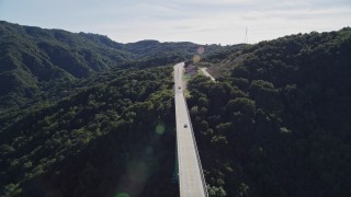 AXSF01_038 - 5K aerial stock footage track black SUV crossing Cold Springs Canyon Arch Bridge, Santa Ynez Mountains, California