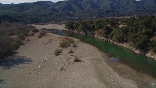 AXSF01_040 - 5K aerial stock footage of flying over dry riverbed, revealing Santa Ynez River, Santa Ynez Valley, California