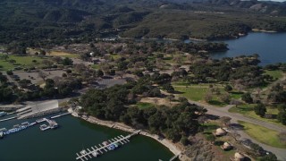 AXSF01_044 - 5K aerial stock footage of approaching an RV Park with boats at the docks, Lake Cachuma, California