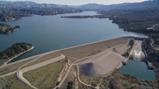 AXSF01_047 - 5K aerial stock footage of flying by the Bradbury Dam, tilt to wider view of Lake Cachuma, California
