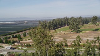 AXSF02_013 - 5K aerial stock footage of flying over a small forest, revealing crop fields, Nipomo, California