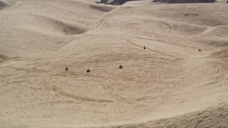 AXSF02_016 - 5K aerial stock footage of flying by ATV riders and sand dunes, Pismo Dunes, California