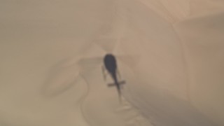 AXSF02_025 - 5K aerial stock footage tracking a helicopter shadow over sand dunes, Pismo Dunes, California