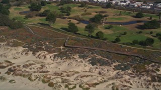 AXSF02_028 - 5K aerial stock footage of flying by a beachside golf course at Pismo Beach, California