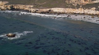 AXSF02_037 - 5K aerial stock footage of flying by waves rolling in toward coastal cliffs, San Luis Obispo, California
