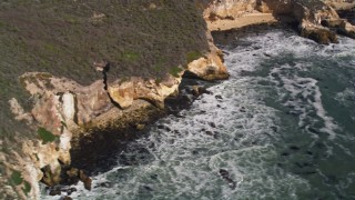 AXSF02_038 - 5K aerial stock footage of flying by ocean waves rolling into coastal cliffs, San Luis Obispo, California