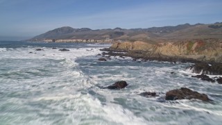 AXSF02_048 - 5K aerial stock footage of flying over waves rolling toward coastal cliffs at Avila Beach, California