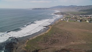 AXSF03_034 - 5K aerial stock footage Tilt to reveal ocean waves rolling into the coast, San Simeon, California