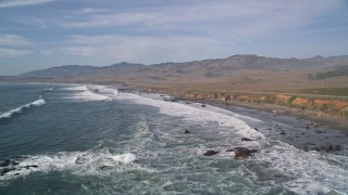AXSF03_037 - 5K aerial stock footage fly over ocean waves by Highway 1 on the coast, San Simeon, California