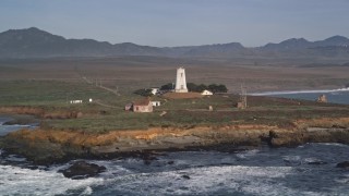 AXSF03_056 - 5K aerial stock footage of passing by Point Piedras Blancas lighthouse, San Simeon, California