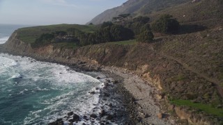 AXSF03_066 - 5K aerial stock footage fly low over coast, approach an oceanfront home, reveal barns, San Simeon, California