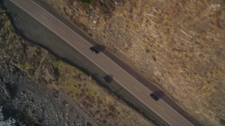 AXSF03_073 - 5K aerial stock footage of a bird's eye view of black cars on Highway 1, above coastal cliffs, Big Sur, California