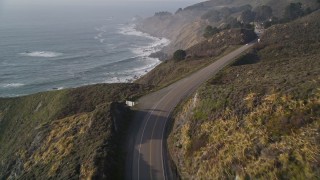 AXSF03_075 - 5K aerial stock footage fly over a bend in Highway 1 in the hills above the coastline, Big Sur, California