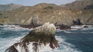 AXSF03_078 - 5K aerial stock footage fly over a large rock formation and coastal cliffs, Big Sur, California
