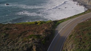AXSF03_079 - 5K aerial stock footage of flying over Highway 1 coastal road, and tilt to ocean waves, Big Sur, California