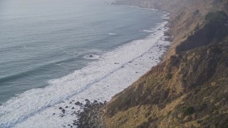 AXSF03_089 - 5K aerial stock footage pan to reveal waves rolling toward cliffs, Big Sur, California