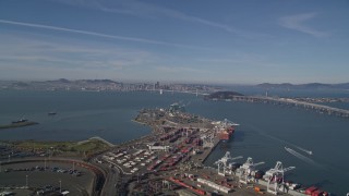 AXSF05_005 - 5K aerial stock footage tilt from shipping containers at the Port of Oakland, reveal Bay Bridge, San Francisco Bay and downtown, California