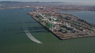 AXSF05_079 - 5K aerial stock footage approach and fly over large cargo cranes at the Port of Oakland, California