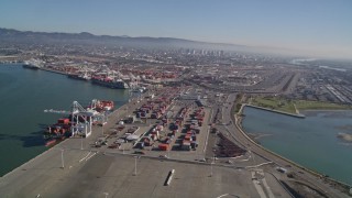 AXSF05_080 - 5K aerial stock footage of panning across shipping containers and flying over the Port of Oakland, California