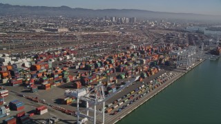 AXSF05_082 - 5K aerial stock footage flying by cargo cranes, and stacks of shipping containers, Port of Oakland, Oakland, California