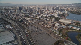AXSF06_005 - 5K aerial stock footage tilt from I-880 freeway and train yard to reveal Downtown Oakland, California