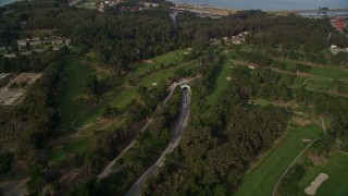 AXSF06_041 - 5K aerial stock footage fly over MacArthur Tunnel and The Presidio Golf Course, tilt to reveal Golden Gate Bridge, San Francisco, California