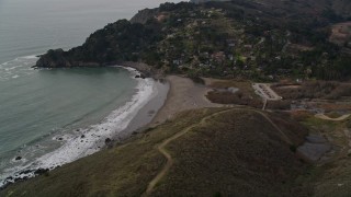 AXSF06_050 - 5K aerial stock footage of panning across hills to reveal Muir Beach and hillside homes, Marin County, California