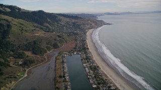 AXSF06_070 - 5K aerial stock footage of flying over marshlands near Lagoon, tilt to reveal beachfront homes, Bolinas, California