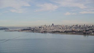 AXSF06_077 - 5K aerial stock footage flying low over the bay and ascending toward Downtown San Francisco skyline, California