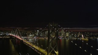 AXSF07_005 - 5K aerial stock footage ascend and fly over Bay Bridge, approach Downtown San Francisco skyline, California, night