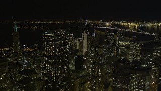 AXSF07_013 - 5K aerial stock footage tilt from apartment and office buildings to fly over skyscrapers in Downtown San Francisco, California, night
