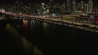 AXSF07_015 - 5K aerial stock footage tilt from bay to reveal Bay Bridge and Downtown San Francisco skyscrapers, California, night