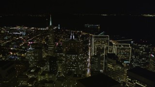 AXSF07_023 - 5K aerial stock footage tilt from busy streets to reveal skyscrapers, Transamerica Pyramid, and Coit Tower,  Downtown San Francisco, California, night