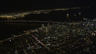 AXSF07_072 - 5K aerial stock footage of a high altitude view of Bay Bridge and skyscrapers in Downtown San Francisco, California, night
