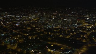 AXSF07_090 - 5K aerial stock footage tilt from light traffic on Interstate 880, reveal and fly over Downtown Oakland, California, night
