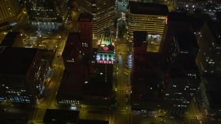 AXSF07_092 - 5K aerial stock footage approach Tribune Tower office building and tilt to bird's eye view, Downtown Oakland, California, night