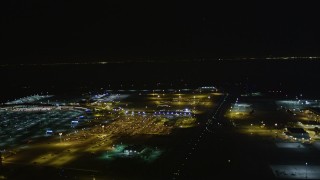 AXSF07_100 - 5K aerial stock footage track a small plane landing at Oakland International Airport, Oakland, California, night